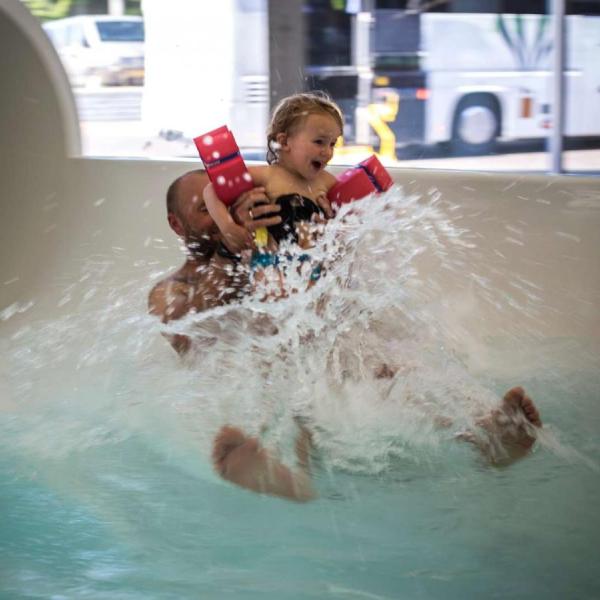 Vater und Tochter kommen in Vandhalla in Hou von der Wasserrutschbahn geflogen