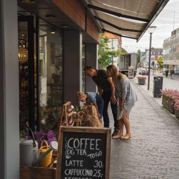 Familie beim Shopping schaut draußen vor einem Laden in Odder Ware an – ein Teil der Urlaubsregion Küstenland
