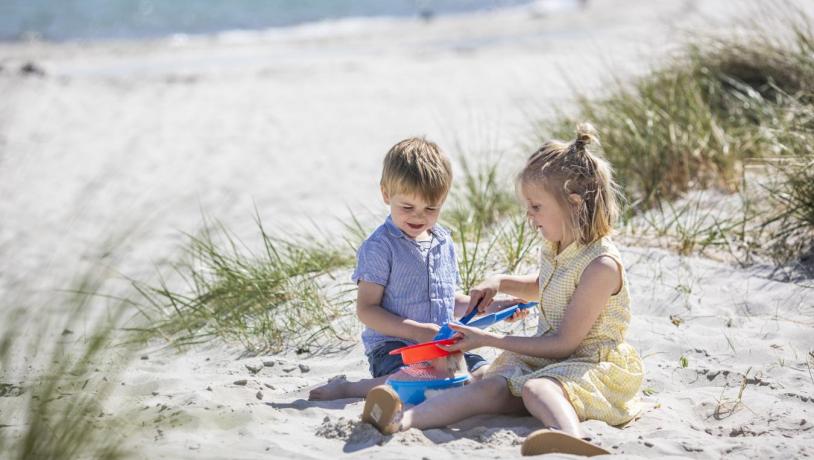 Kinder spielen am Saksild Strand im Sand