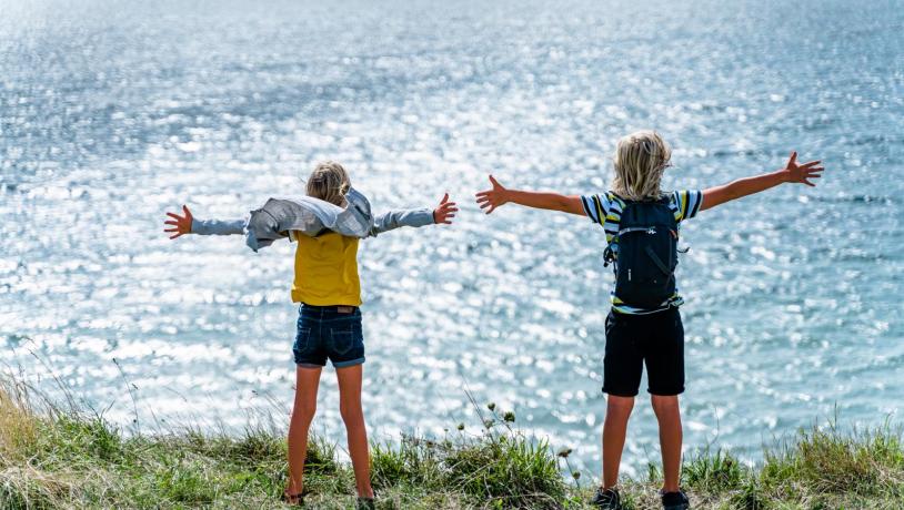 Zwei Kinder stehen an der Küste