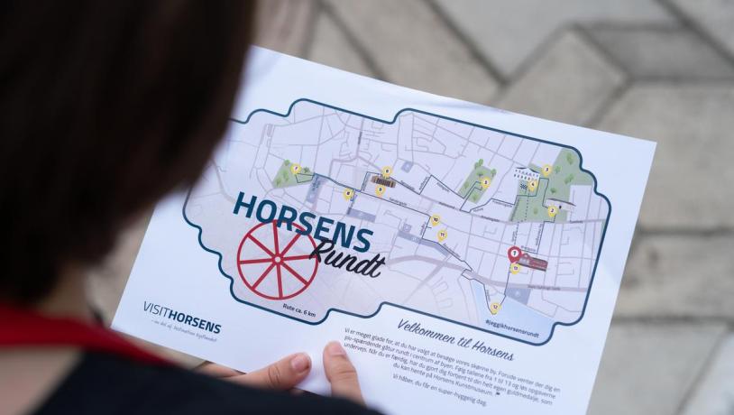 Kind hält Schatzkarte für die Familienaktivität „Schatzsuche rund um Horsens“