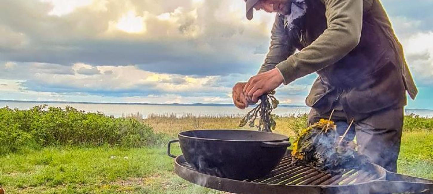 Kochen über dem Feuer auf der Algenfarm auf Endelave