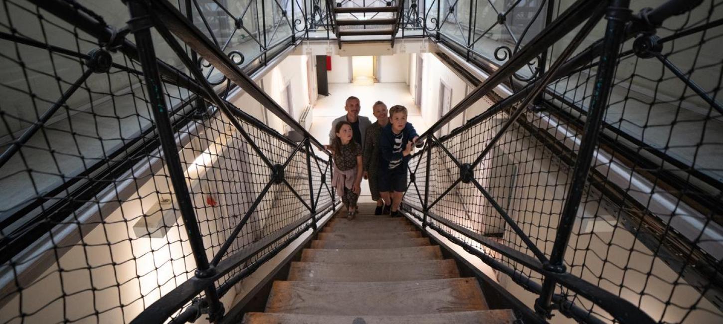 Familie steigt eine Gefängnistreppe hinauf