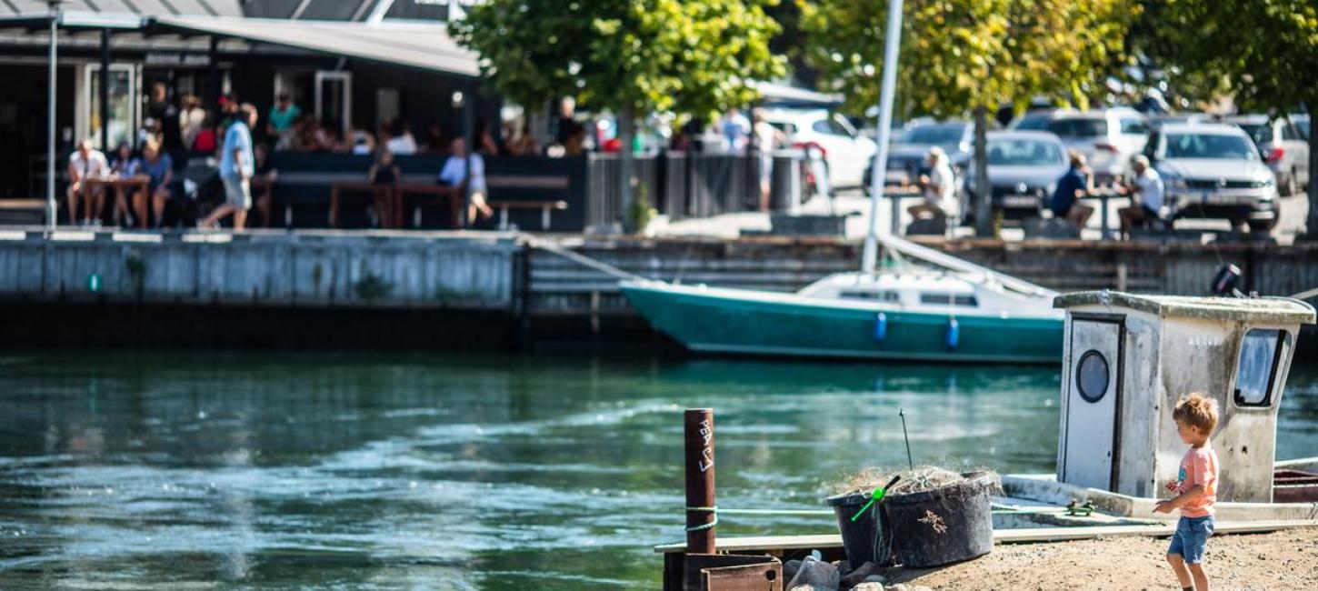 Junge steht beim Hafen in Norsminde