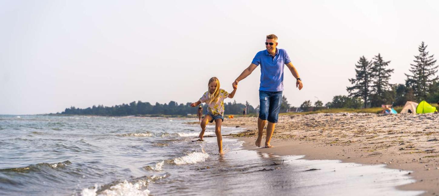 Vater und Tochter an der Wasserkante am Saksild Strand