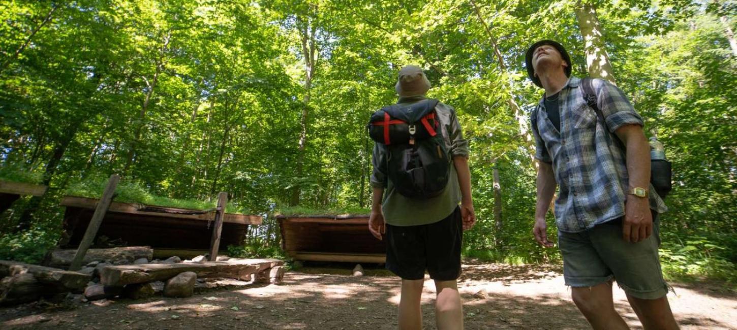 Zwei Männer auf Wanderung am Shelterplatz im Wald
