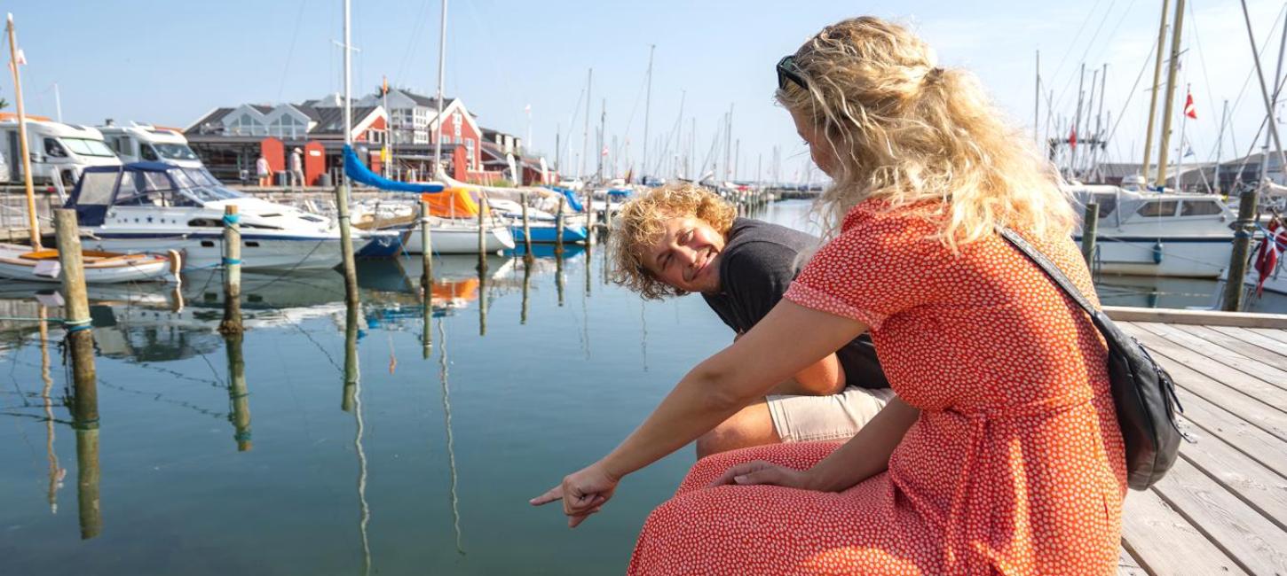 Paar genießt die gemütliche Stimmung im Hafen in Dänemarks gemütlichster Hafenstadt, Juelsminde – ein Teil der Urlaubsregion Küstenland