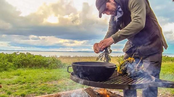 Kochen über dem Feuer auf der Algenfarm auf Endelave