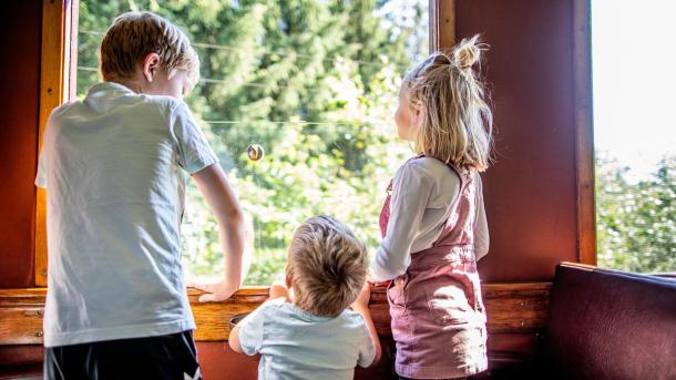 Kinder stehen in einem Eisenbahnwaggon der Museumsbahn Bryrup