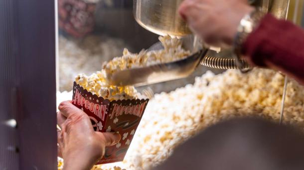 Im Biffen in Odder in der Urlaubsregion Küstenland wird ein Becher mit Popcorn gefüllt