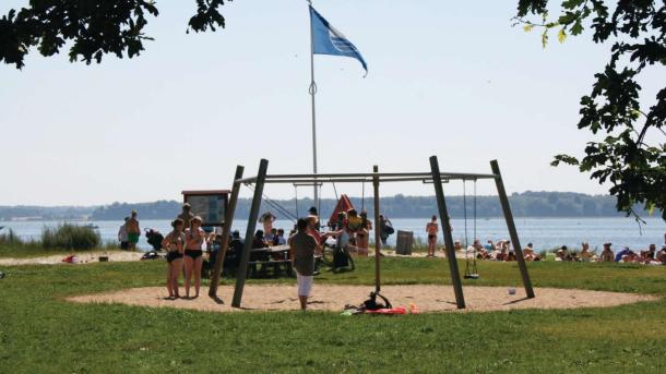 Kinder, die auf dem Spielplatz von Horsens City Camping am Husodde Strand in Horsens spielen – ein Teil des Küstenlandes