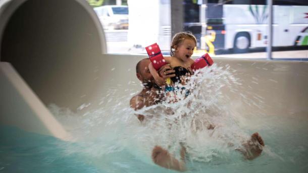 Vater und Tochter kommen in Vandhalla in Hou von der Wasserrutschbahn geflogen