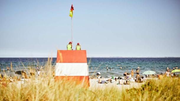 Lebensretterturm am Saksild Strand mit Gästen auf dem Strand