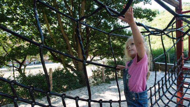 Mädchen klettert im Netz auf dem Spielplatz im Bygholm Park