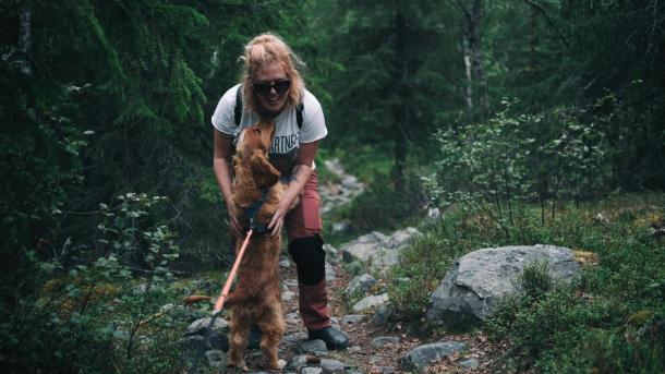 Frau umarmt ihren Hund im Wald