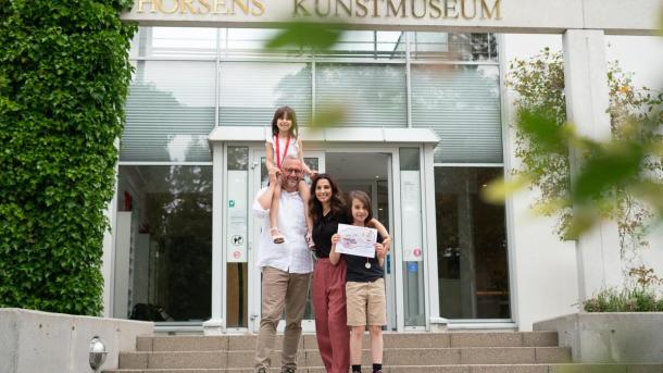 Familie begibt sich für die Schatzsuche rund um Horsens am Kunstmuseum auf einen Spaziergang