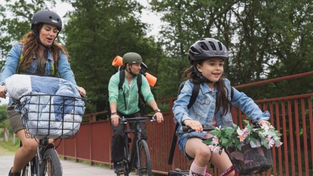 Familie mit Vater, Mutter und Mädchen auf Radtour auf dem Bryrupbanestien bei der wiederentdeckten Brücke im Küstenland