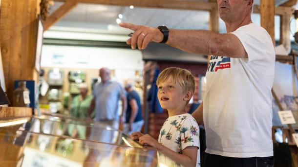 Junge und sein Vater schauen sich die Schiffsausstellung im Hafenmuseum in Juelsminde an