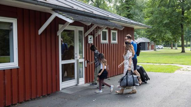 Familie  på vej ind i hytte ved Hou Søsportcenter