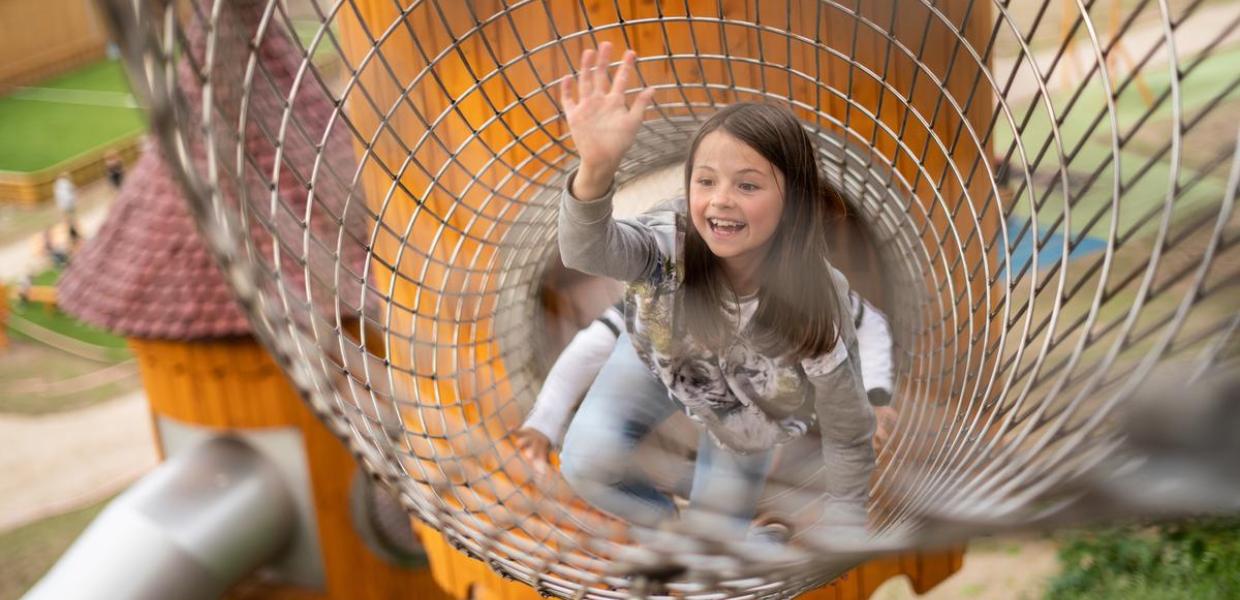 Ein Mädchen im Turm des Naturspielplatzes in Juelsminde