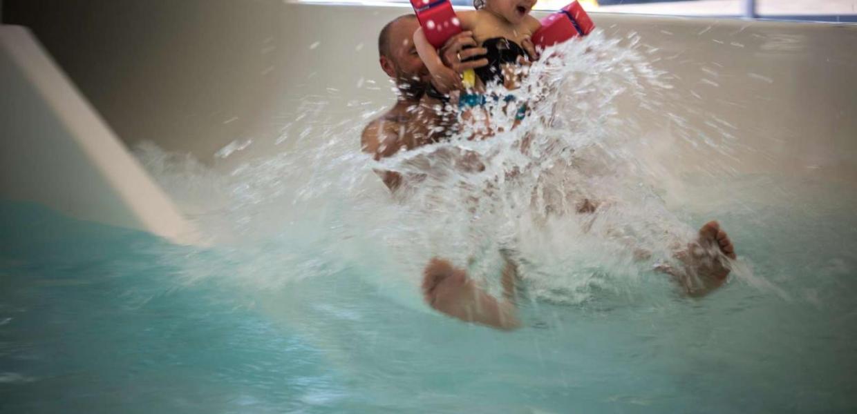 Vater und Tochter kommen in Vandhalla in Hou von der Wasserrutschbahn geflogen