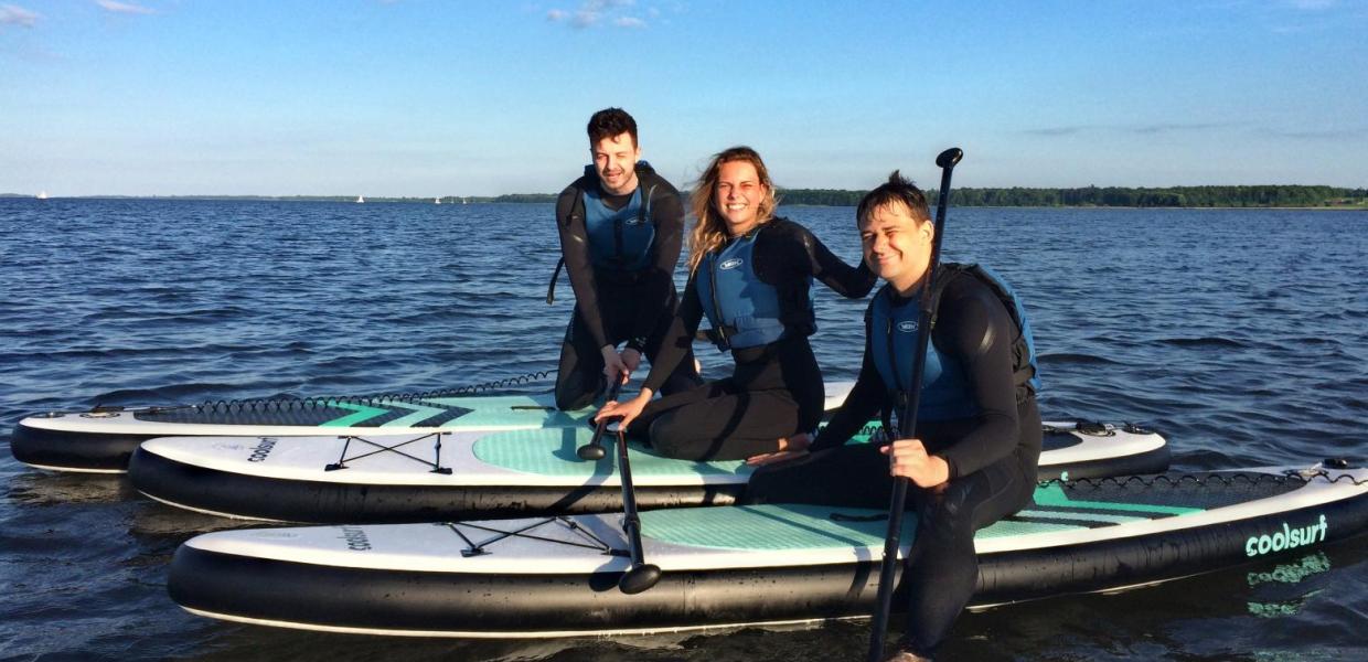 Drei Freunde auf SUP-Boards auf dem Horsens Fjord