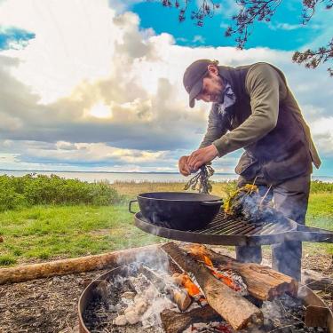 Kochen über dem Feuer auf der Algenfarm auf Endelave