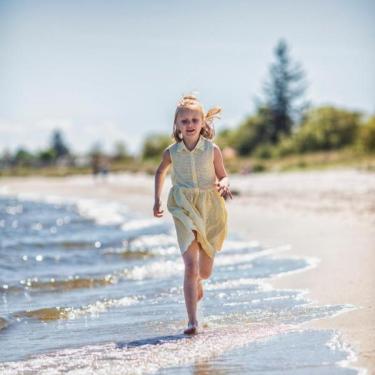 Mädchen läuft auf dem Strand bei Saksild