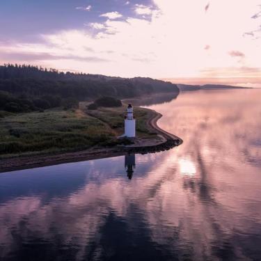 Ausblick auf Küste und Leuchtturm beim Hotel Vejlefjord im Küstenland