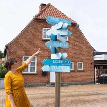Frau zeigt auf Schild in Juelsminde