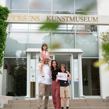 Familie begibt sich für die Schatzsuche rund um Horsens am Kunstmuseum auf einen Spaziergang