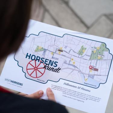 Kind hält Schatzkarte für die Familienaktivität „Schatzsuche rund um Horsens“