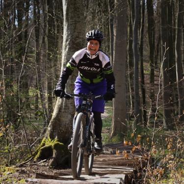 Frau fährt auf dem Mountainbike auf dem Trail im Tofteskov in Juelsminde