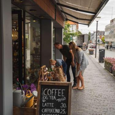 Familie beim Shopping schaut draußen vor einem Laden in Odder Ware an – ein Teil der Urlaubsregion Küstenland