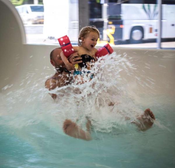 Vater und Tochter kommen in Vandhalla in Hou von der Wasserrutschbahn geflogen