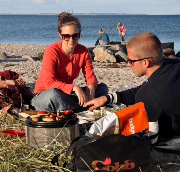 Familie macht es sich am Strand beim Ajstrup Camping gemütlich und grillt – ein Teil der Urlaubsregion Küstenland