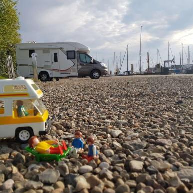 Spielzeug-Wohnmobil vor echtem Wohnmobil auf dem Wohnmobilplatz in Juelsminde