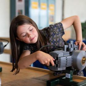 Mädchen spielt mit einem Motor im Industriemuseum in Horsens