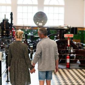 Paar geht und sieht sich die Ausstellung in Dänemarks Industriemuseum an