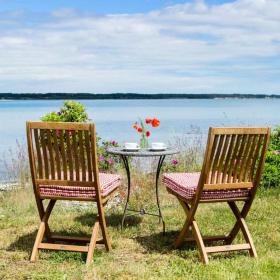 Zwei Gartenstühle und ein Tisch hinunter zum Strand in der Urlaubsregion Küstenland