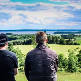 Zwei Jungen sitzen auf dem Aussichtshügel bei Trustrup und genießen die Aussicht