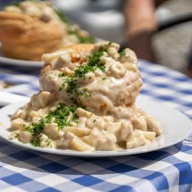 Tisch mit blau karierter Decke und Dänemarks größten Tartelettes im Café Alrø im Horsens Fjord – ein Teil der Urlaubsregion Küstenland