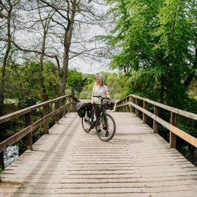 Eine Frau fährt mit einem Elektrofahrrad in der Nähe der Wiederentdeckten Brücke.