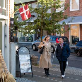 Mand og kvinde går udenfor butik Fru Skov i Brædstrup 