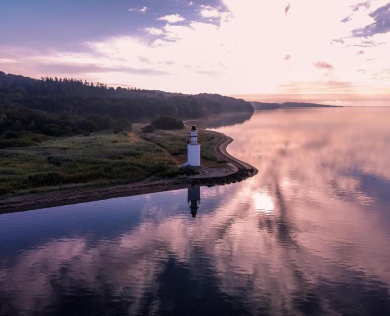 Ausblick auf Küste und Leuchtturm beim Hotel Vejlefjord im Küstenland